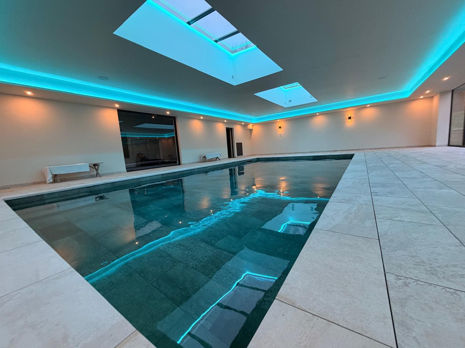 Pool Build indoor swimming pool with turquoise lighting